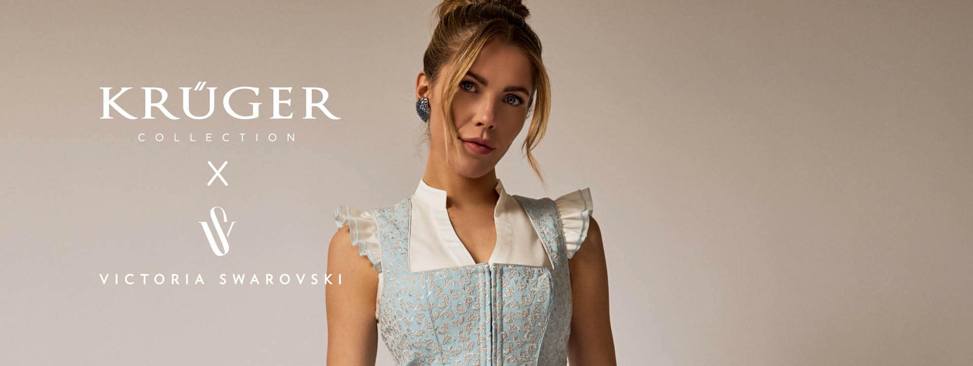 Victoria Swarovski draagt een lichtblauwe dirndl met koi-details en een bijpassende dirndlblouse met vleugelmouwen uit haar eigen collectie.